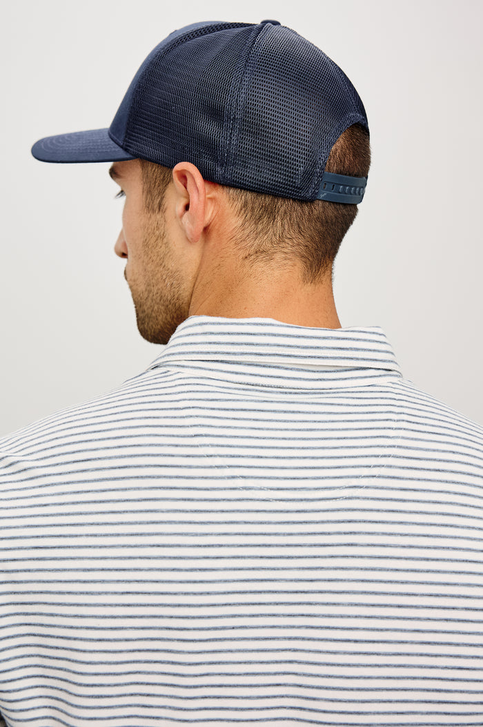 Golf Hat With Embroidered Branded Patch at Front, Adjustable Snapback, Mesh Back, and 6-Panel Construction in Navy Colorway - Upper Body Back View Featured on Model