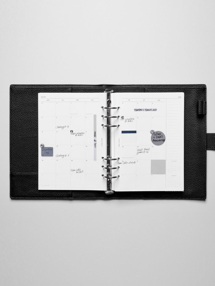 Image shows the Monday Start 2026 Dated Monthly Planner Inserts used in a black leather A5 ring-bound planner. Stickers and sticky notes highlight the notes.