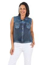 Woman wearing a blue denim vest over a white top on a white background.