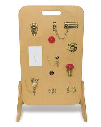 Locks And Latches Board with various locks, chains, switches, and knobs on a freestanding wooden panel for fine motor skill development