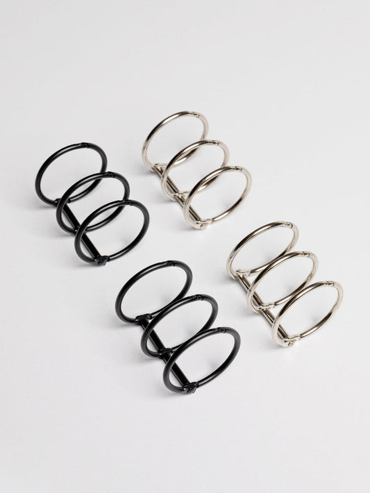 Two sets of 1.25 inch planner rings displayed on a neutral background. One set is black, the other is silver.