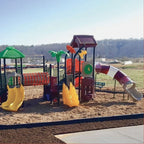 Durable black plastic playground border with spike enclosing colorful children's play structure with slides and climbing features